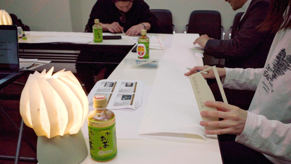 型枠とインク切れのボールペンを持ちいて和紙に折り線を引いている