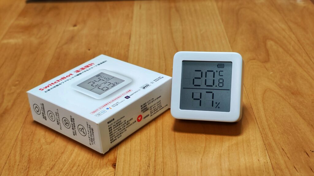 SwitchBot温湿度計が木のテーブルに置かれている