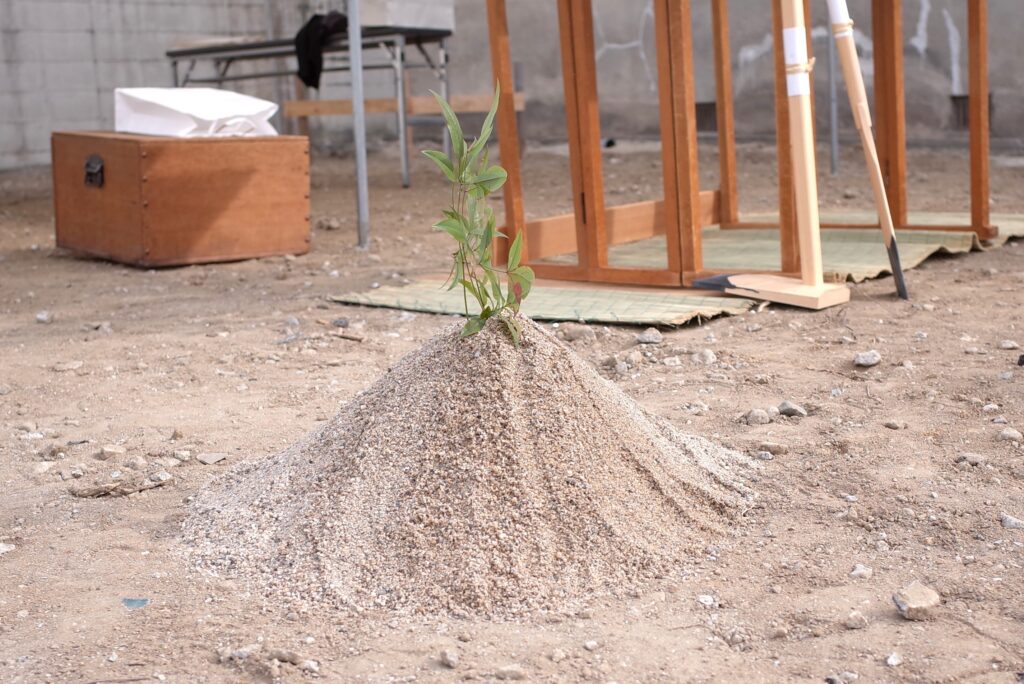 地鎮祭の築山。小さな砂山の上に土地に生えていた草木が差さっている