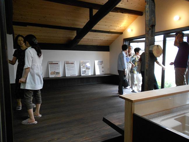 完成見学会の様子、古材の梁が見える2階リビングを来場者が見学