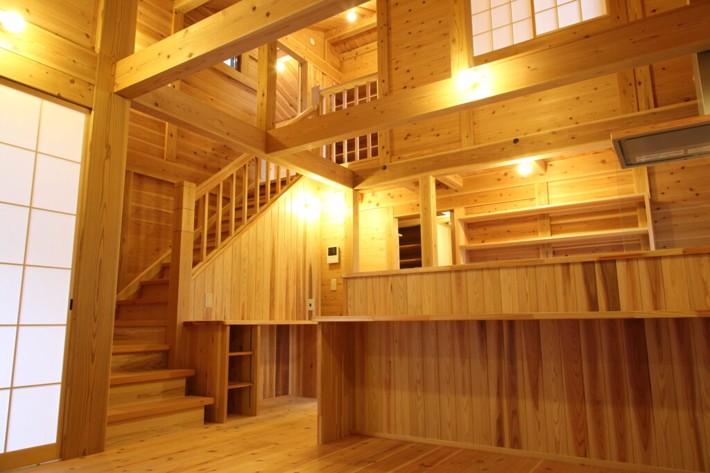 完成した板倉造りの家の勾配天井と吹き抜けのあるリビング