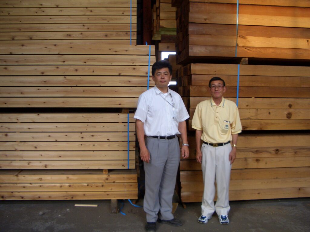 徳島の製材所にて大工さんと杉板の前で記念撮影