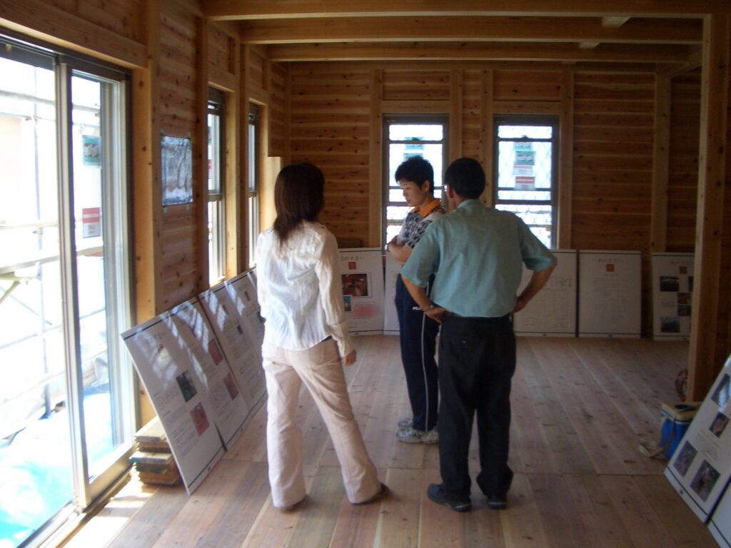 板倉造りの解説を興味深そうに眺める来場者