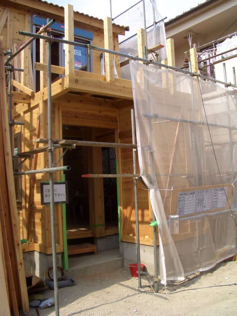 板倉壁が組み上がった建物外観と足場