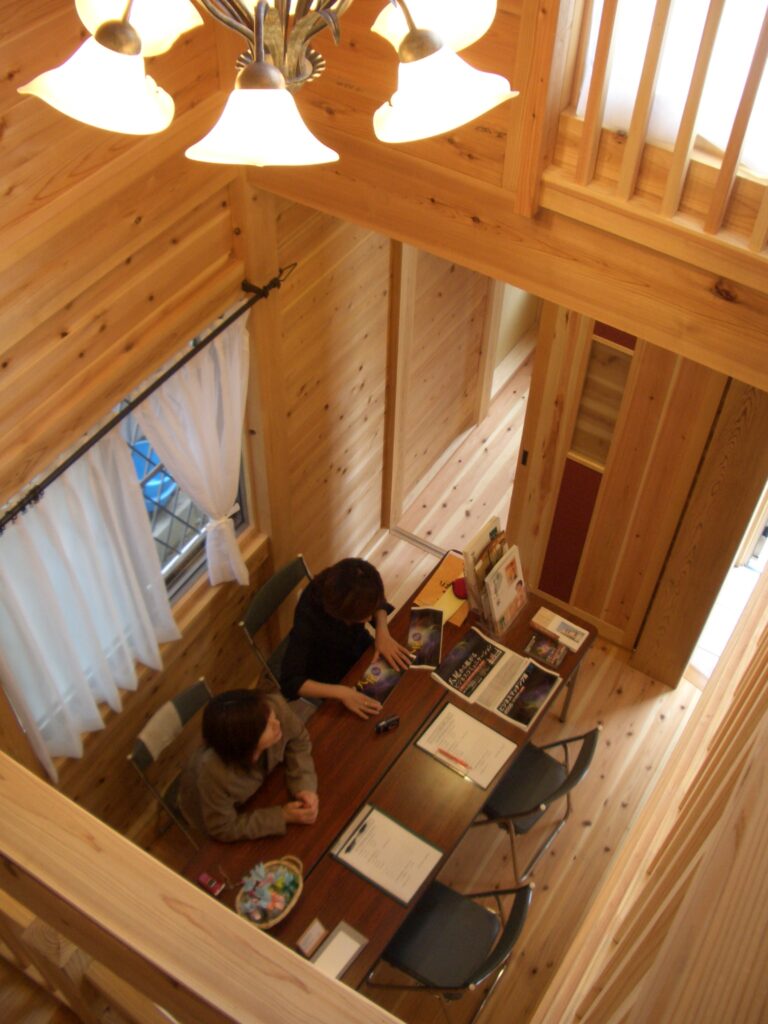 吹き抜けの玄関ホールを上から見下ろした様子。杉板に囲まれた温かみのある空間