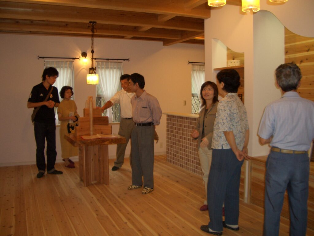 リビングで板倉造りについて説明を受ける見学会の来場者たち