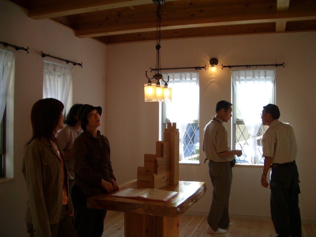 完成見学会で板倉造りの構造模型を見ながら説明を聞く来場者