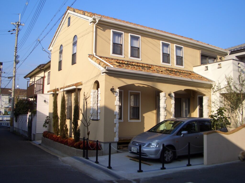 完成した板倉造りの家の外観。ヨーロッパ風のデザインと植栽が調和した美しい佇まい