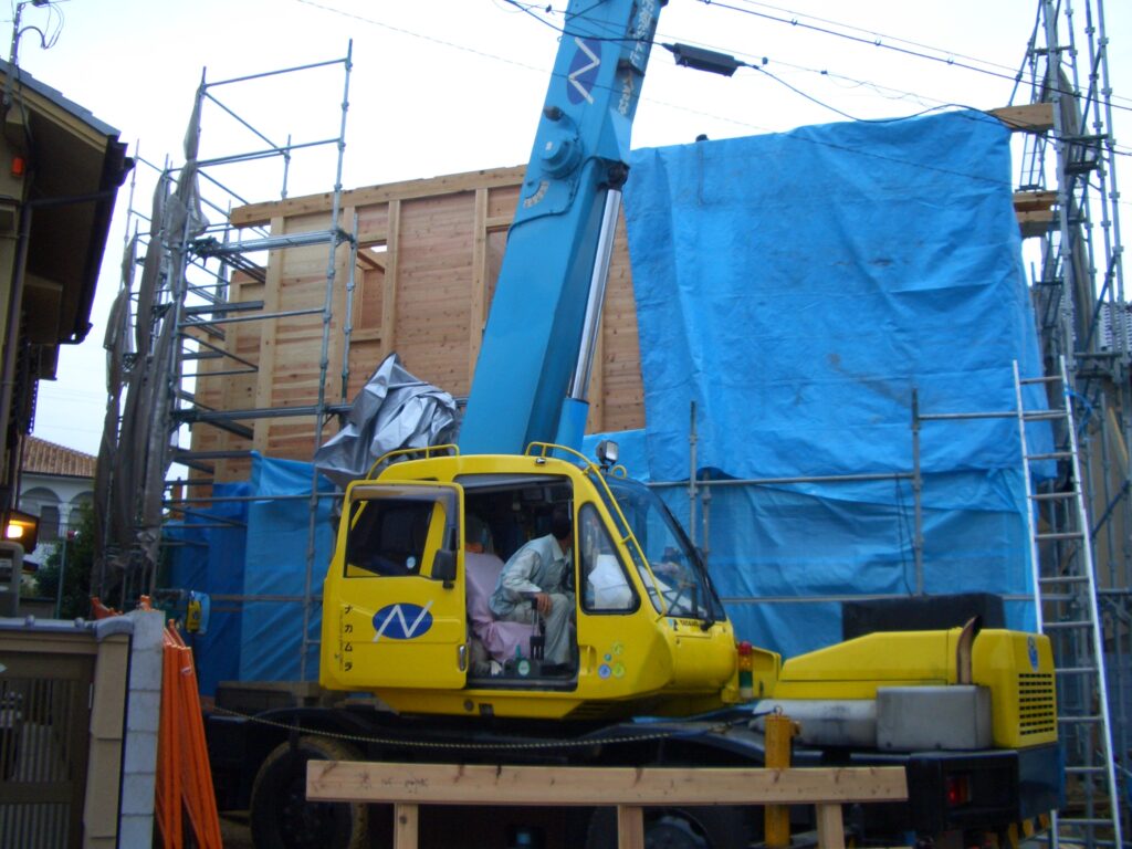 台風に備えて建物全体をブルーシートで覆って雨養生する様子