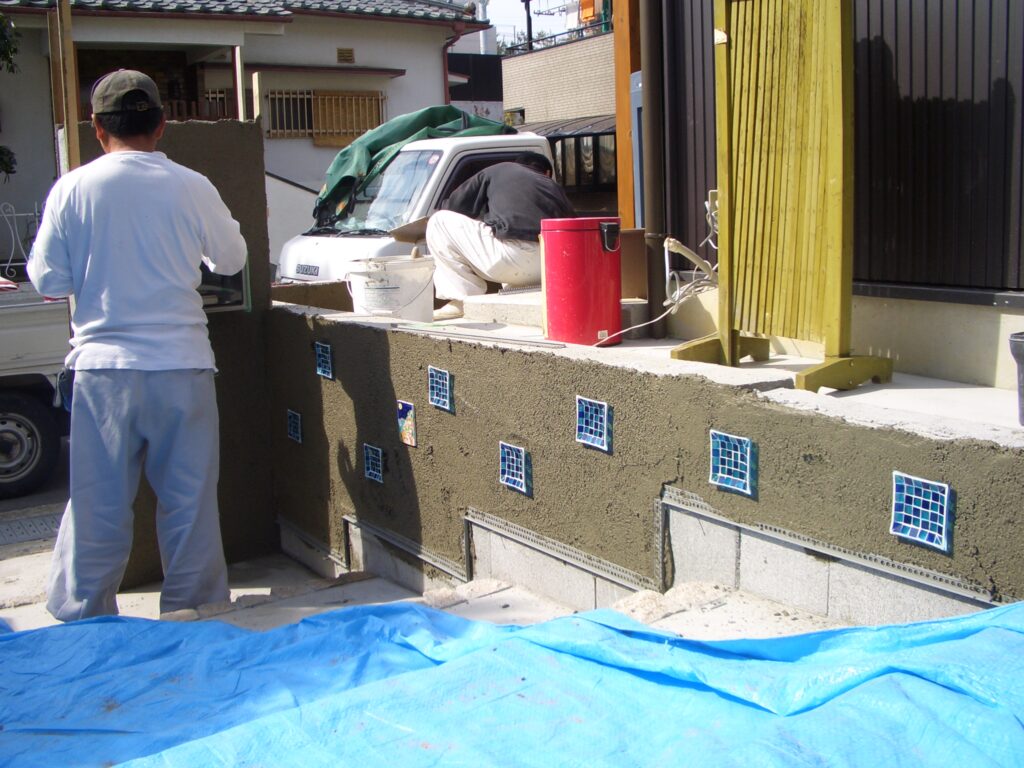 外壁にガラスの小皿を埋め込んだ装飾壁