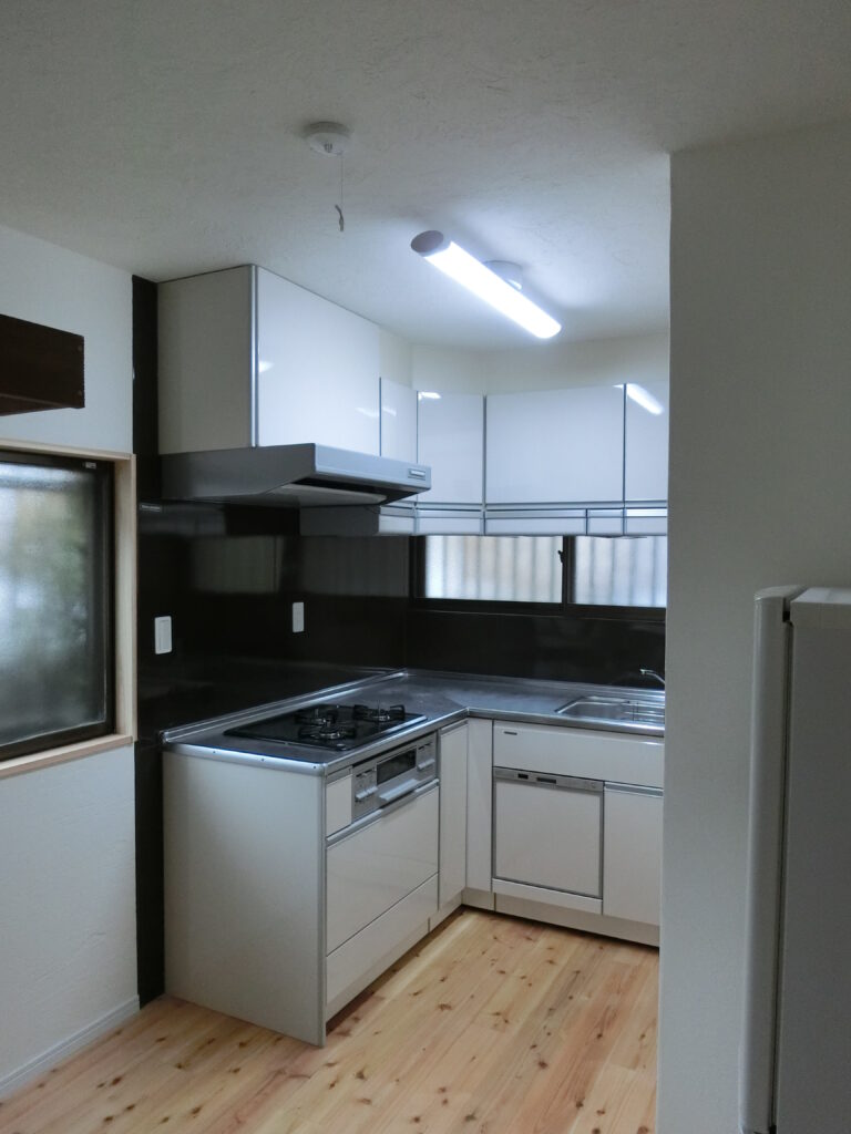 改修後のL型キッチンと無垢杉材の床