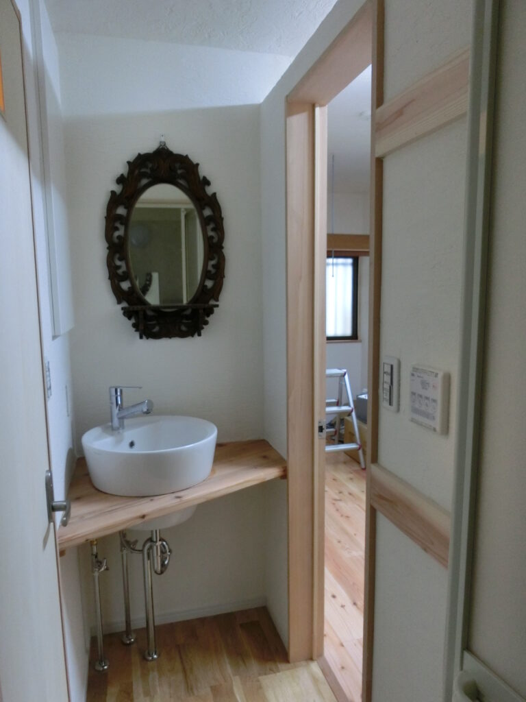 改修後の独立した洗面所(木製カウンターと陶器の洗面ボウル)