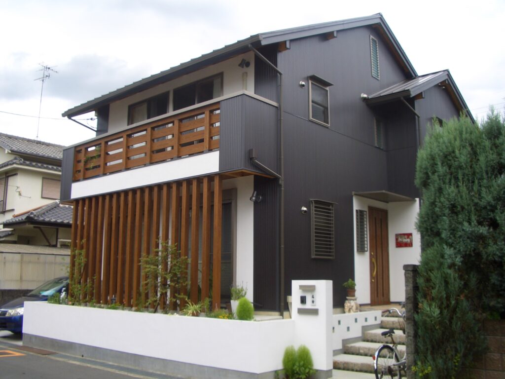 完成した板倉造り住宅の外観。焼杉と漆喰の外壁に植栽が添えられている