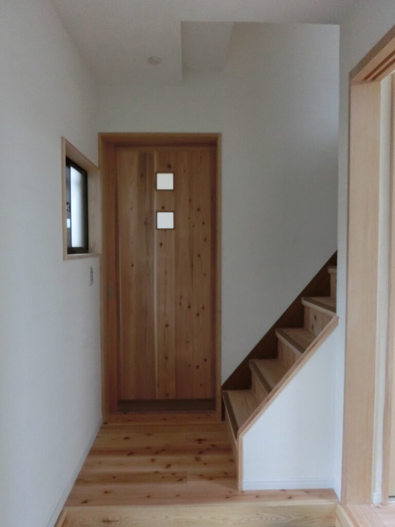 改修後の玄関(無垢材の建具と杉の床)