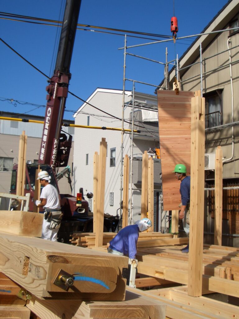 建て方初日に柱を建て杉板を落とし込んでいる作業の様子