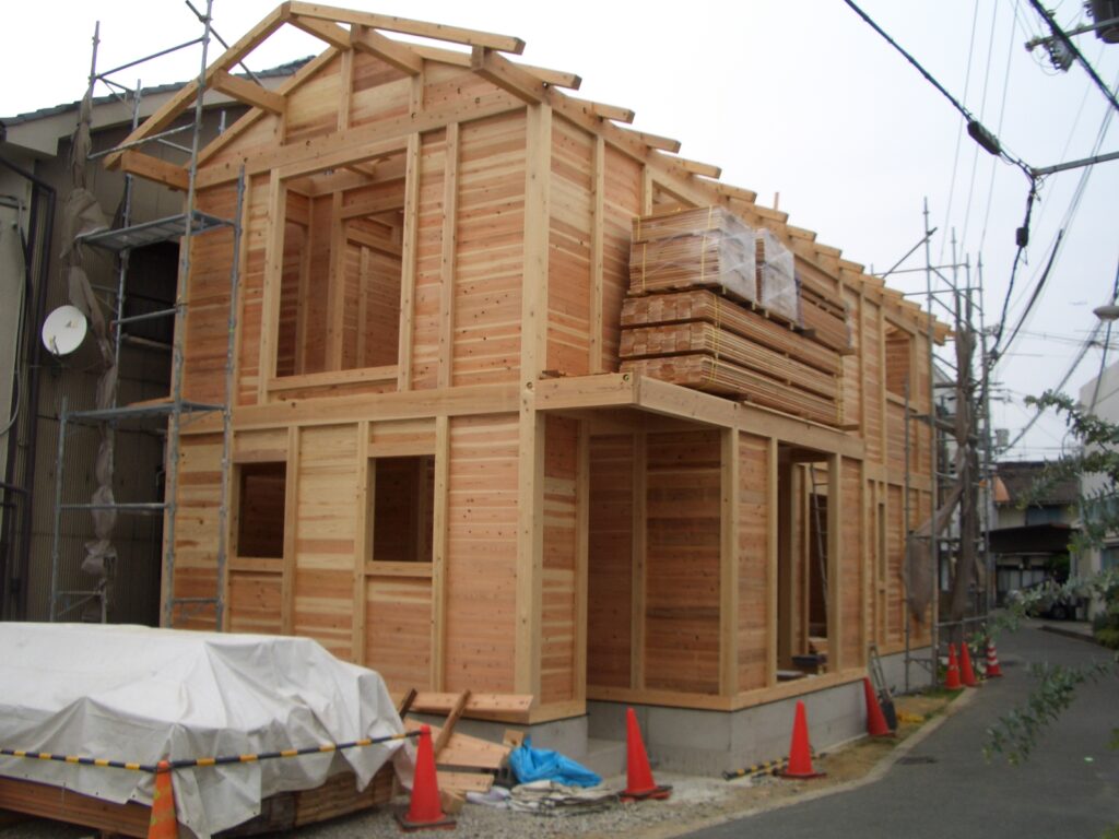 上棟した板倉造りの家の外観。杉の木組みの構造が見える