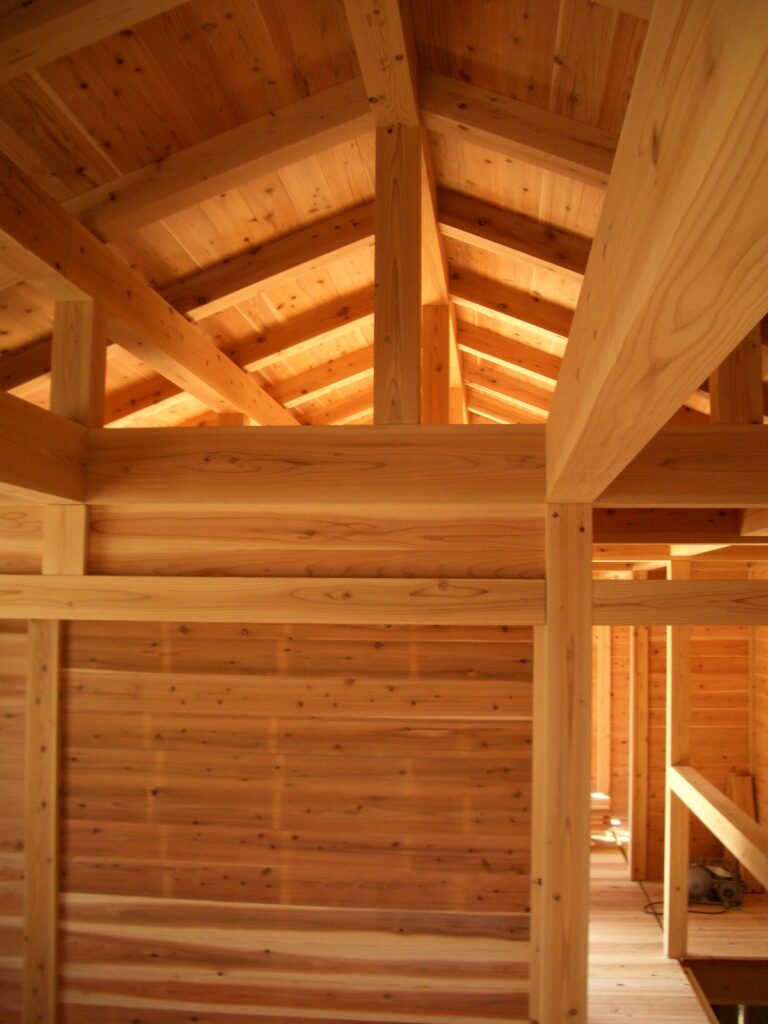 内部工事中の室内。杉の柱・梁・天井の木組み構造が見える