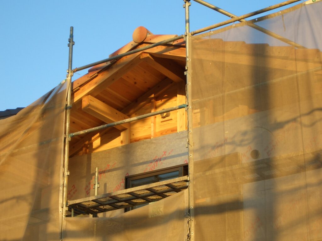 外壁に遮熱シートを張った状態を足場越しに見た様子