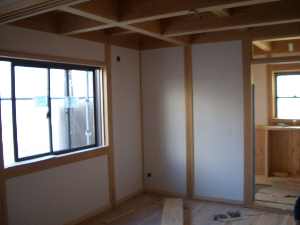 和室の壁に土佐和紙を貼っている内装仕上げの様子