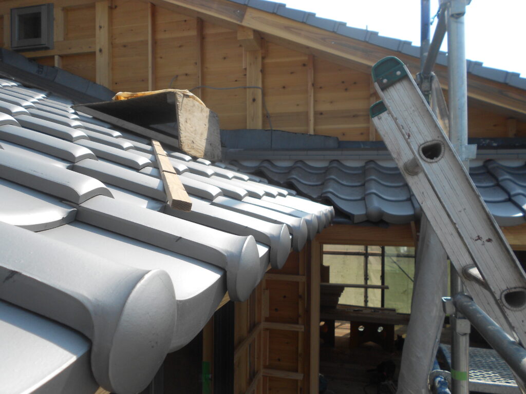 屋根に和瓦を葺いている工事の様子