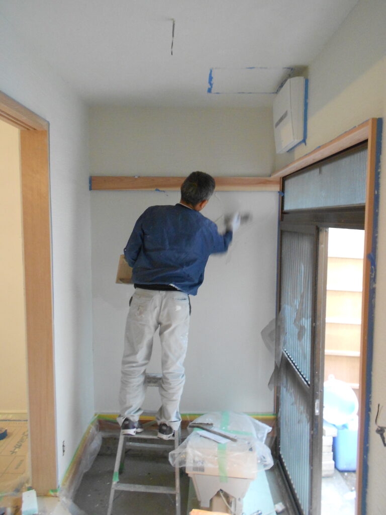 左官職人が漆喰を塗っている施工中の様子