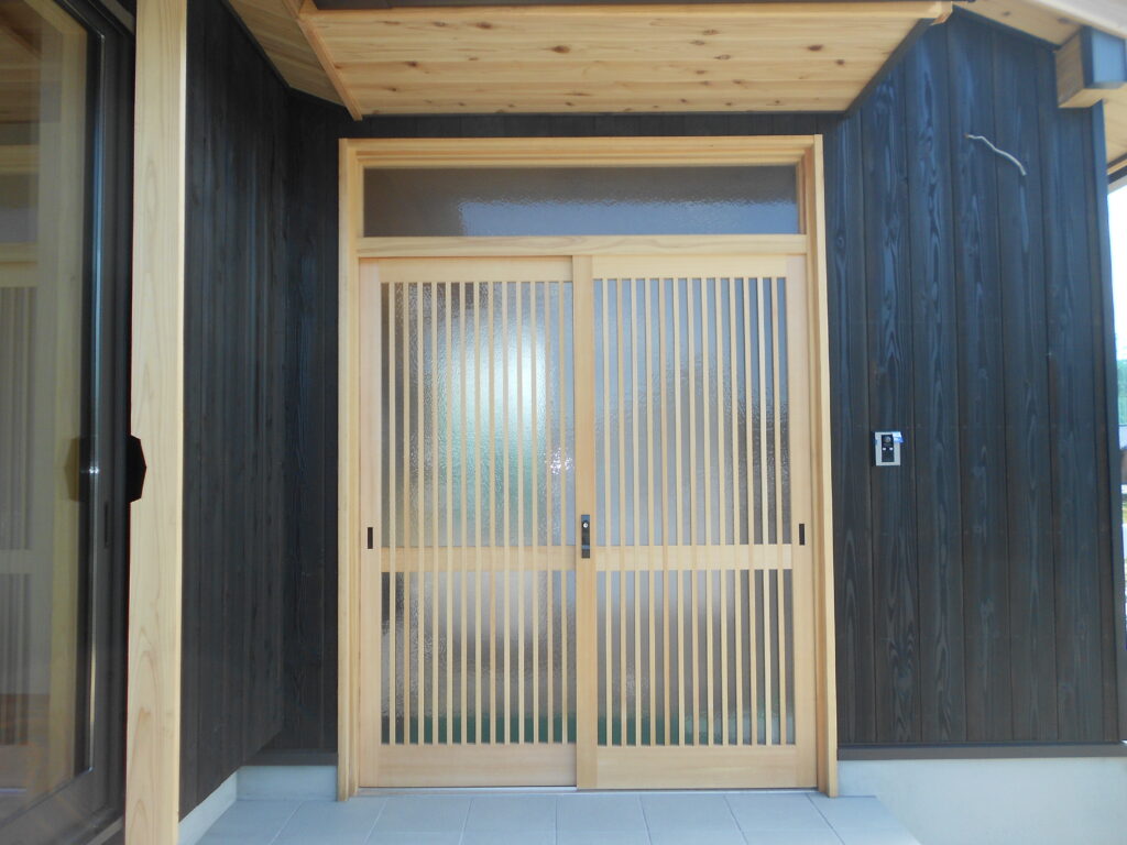 焼杉に映えるの木製引違戸の玄関