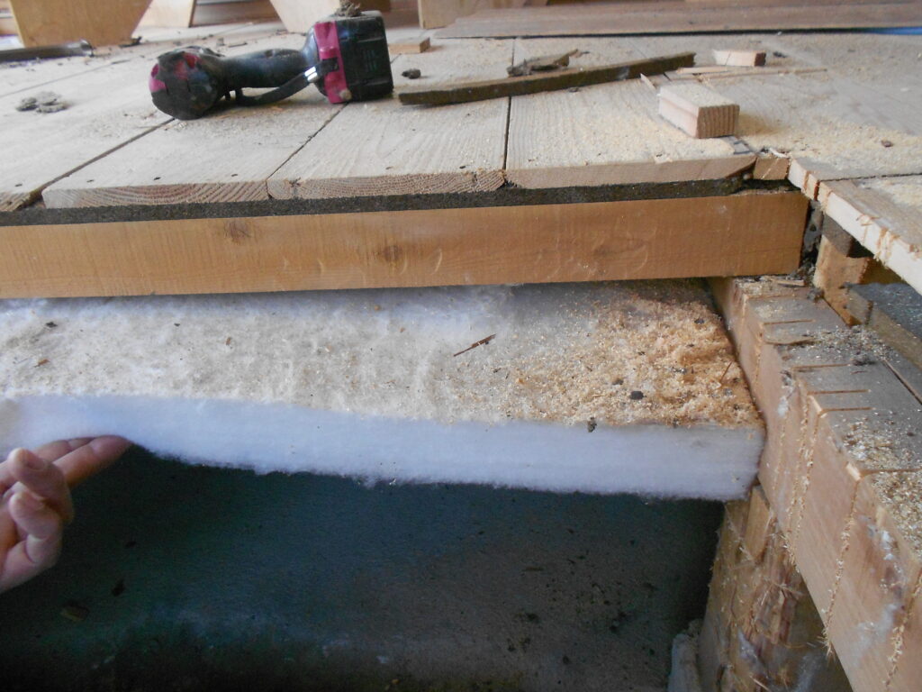 床下に断熱材を敷き込んでいる施工の様子