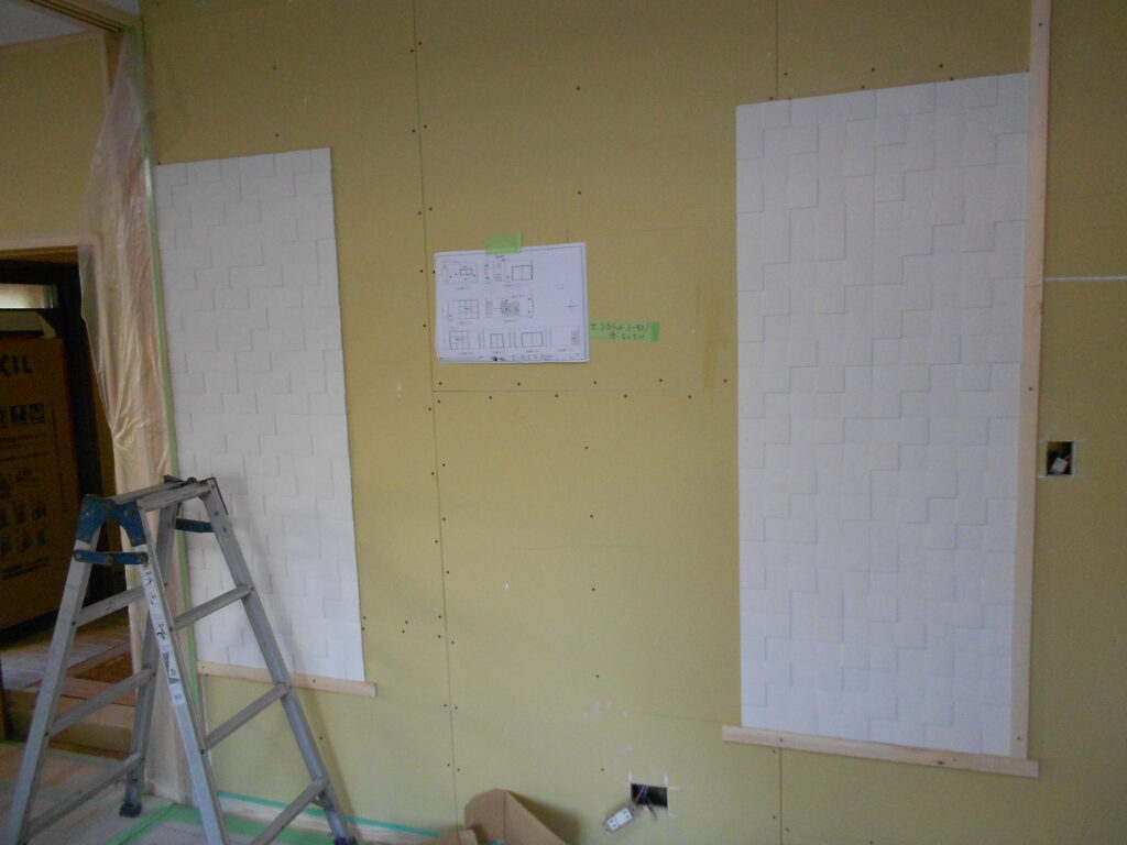 リビングの壁にエコカラットを貼っている施工の様子