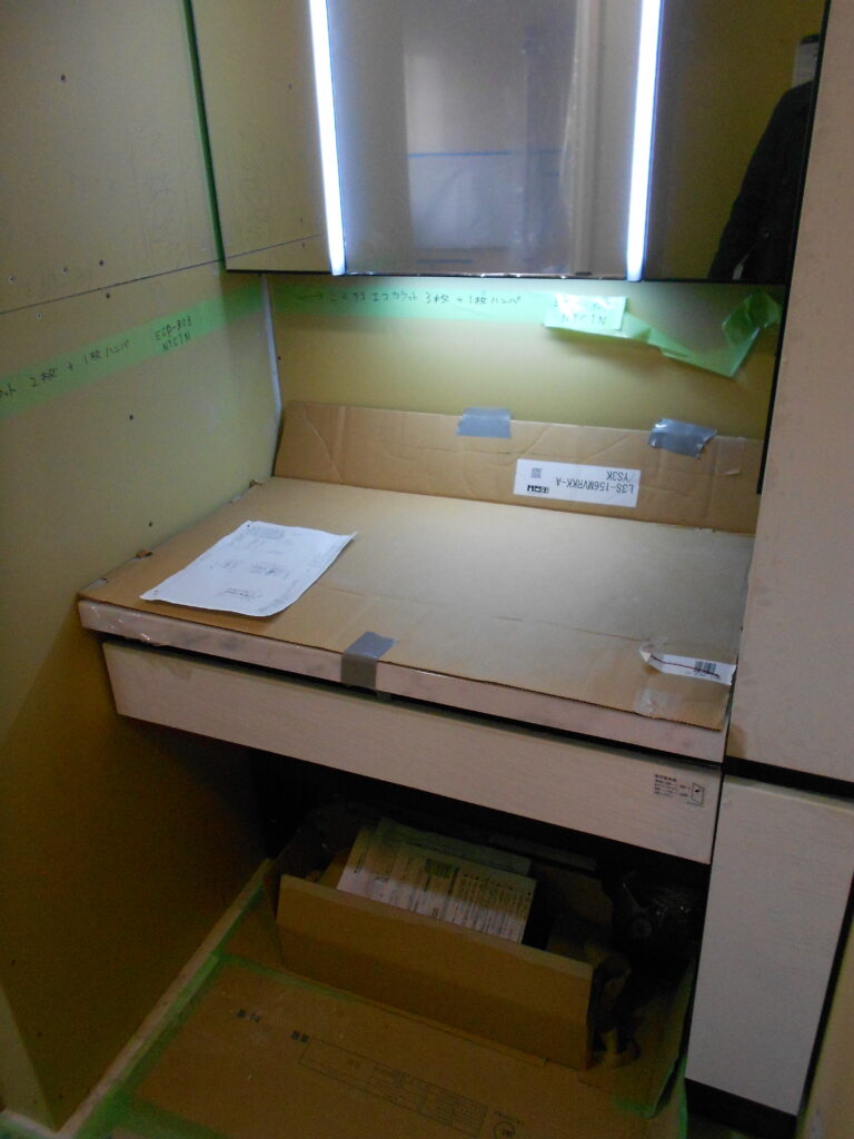 L型の洗面化粧台を据え付けている様子