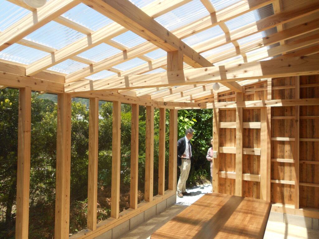 三和土の床と虫よけネットで風が通るテラス内部