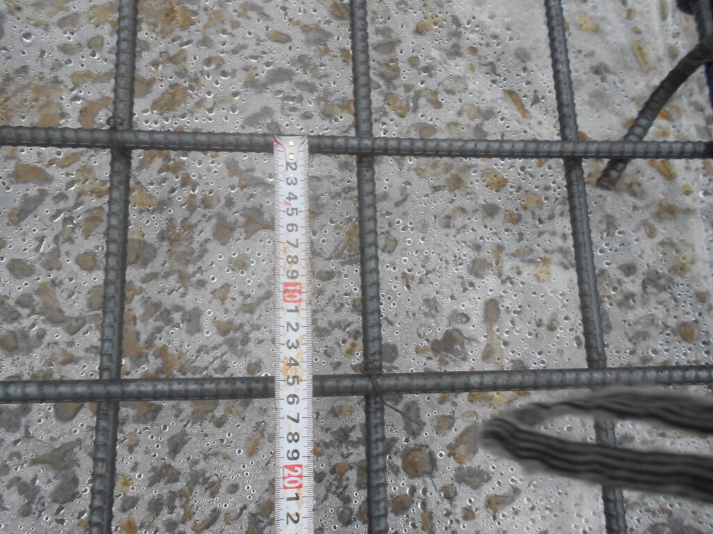 基礎の配筋工事で鉄筋の間隔を確認する様子