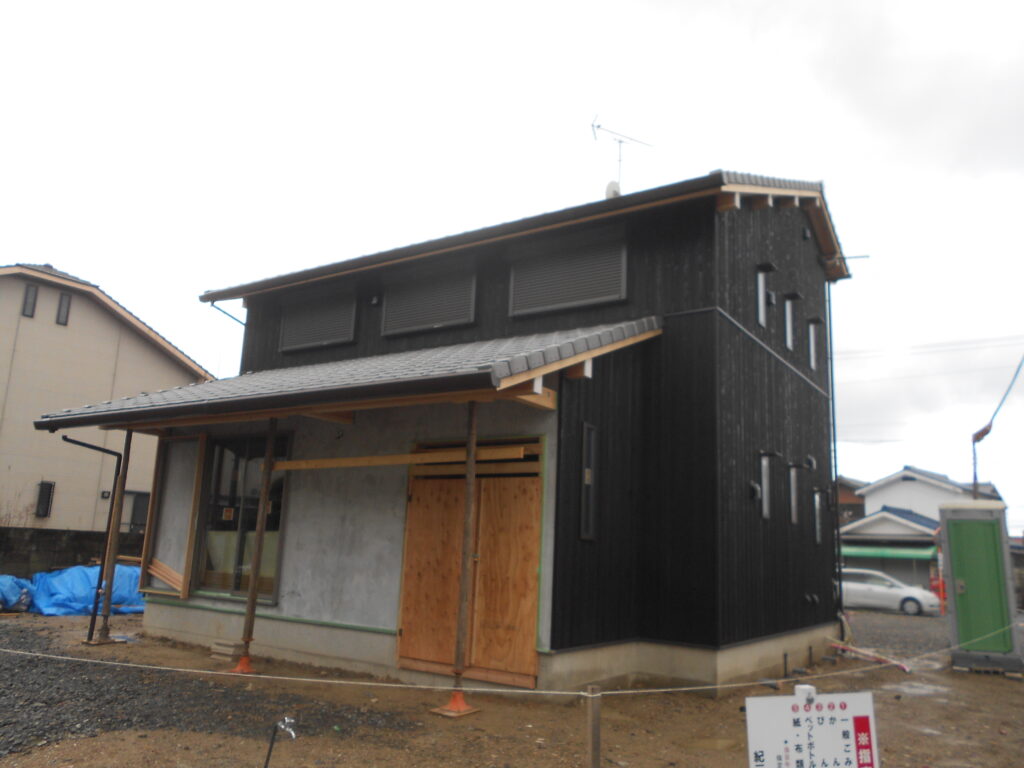 足場が解体され焼杉の外壁といぶし瓦の屋根が見える建物全景