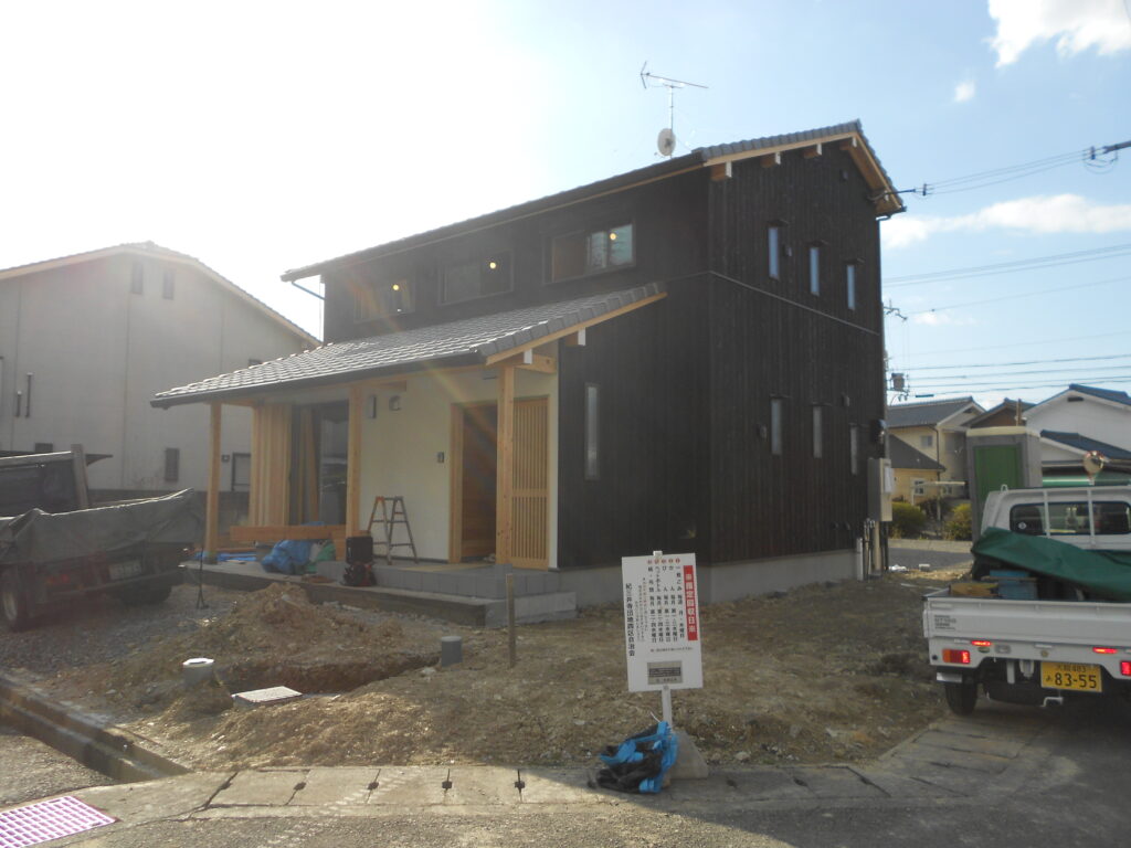 漆喰仕上げの外壁と焼杉が調和した建物の外観