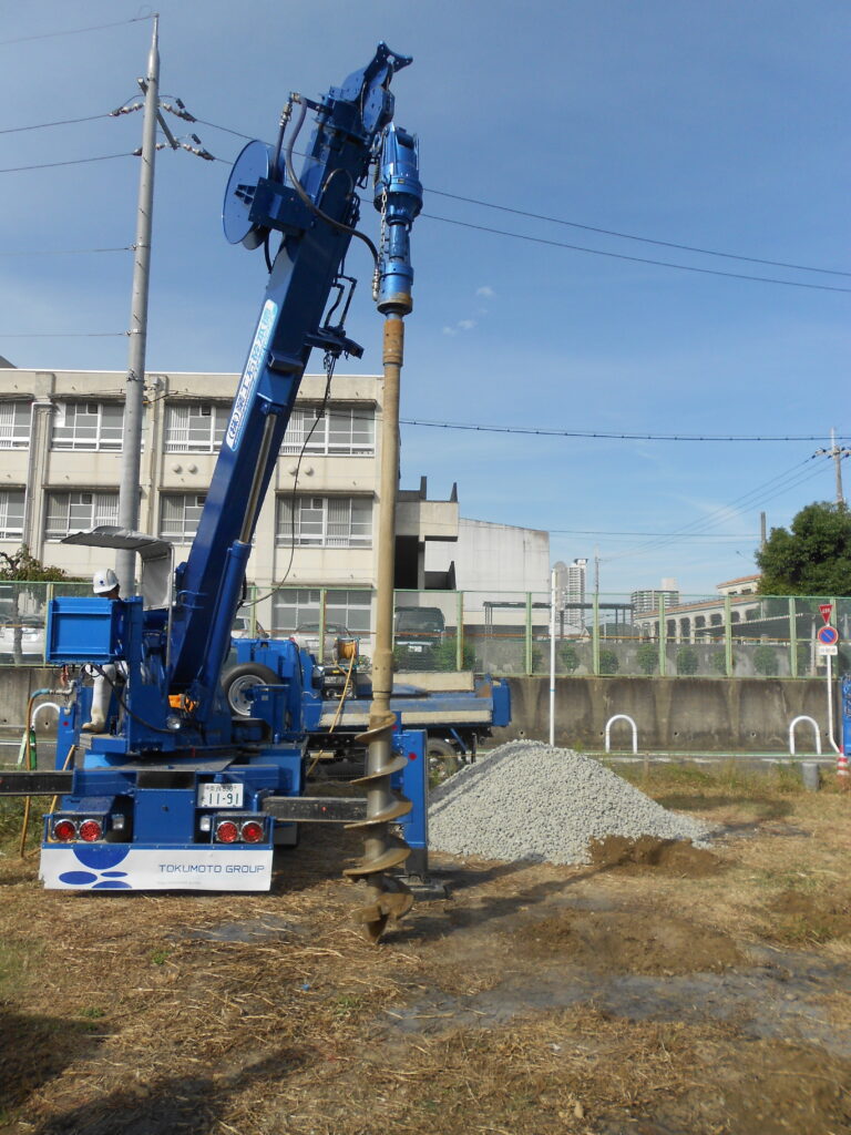 砕石を使った地盤改良工事の掘削機