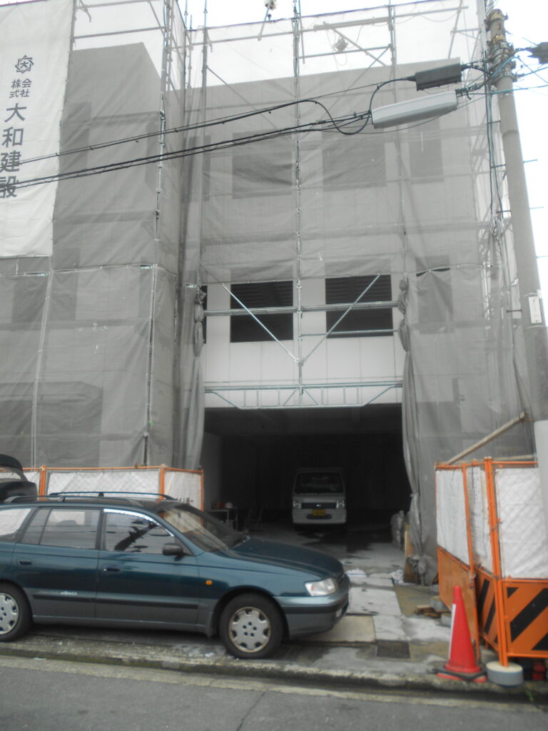 外壁ALC工事が完了し足場に覆われた事務所ビルの外観