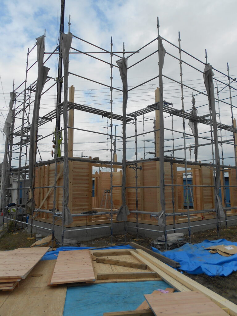 板倉造りの建て方で1階の柱と壁板を組む様子