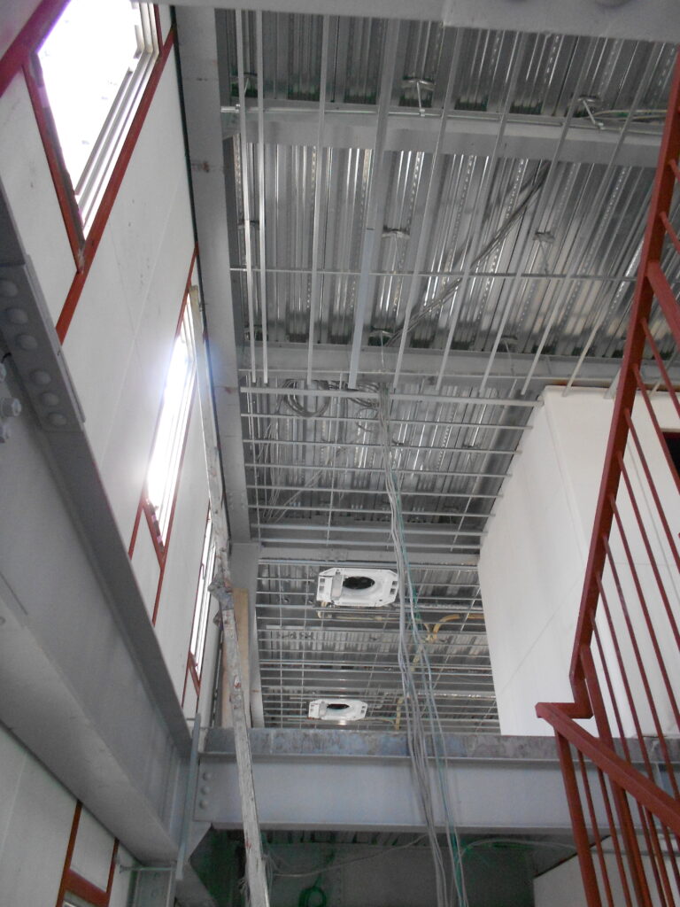 天井に軽量鉄骨の下地と空調設備の配管が施工された様子