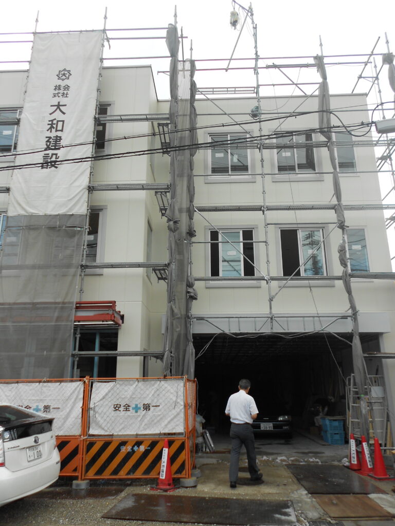 足場を組んで外壁塗装を行っている事務所ビル