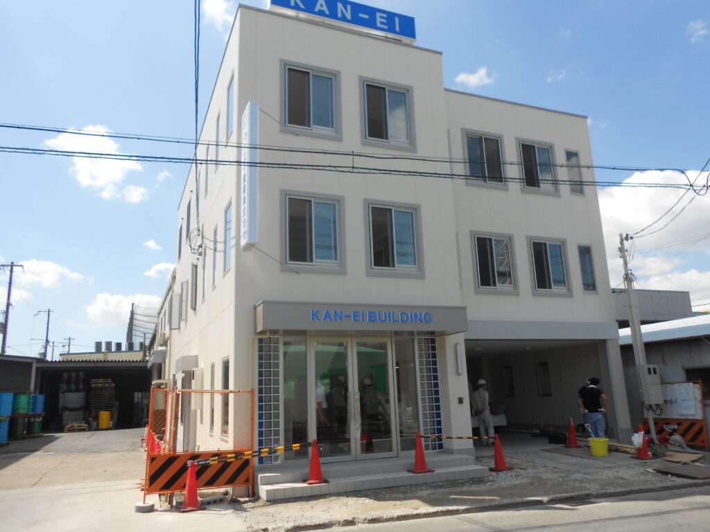 看板が設置された完成間近の事務所ビル外観