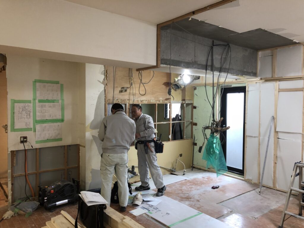 部分解体工事中に間仕切り変更の作業を行う職人