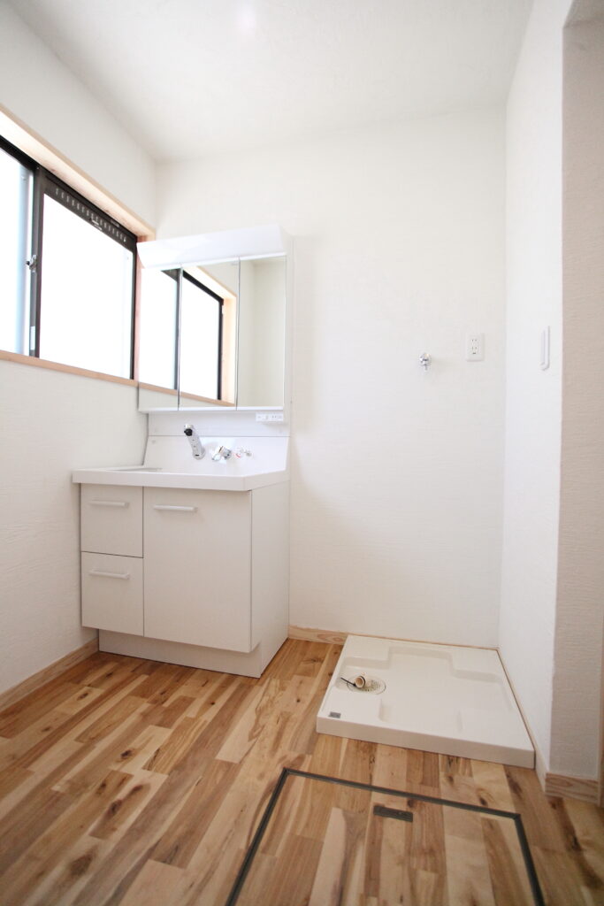 改修後の洗面所。広葉樹の無垢材の床と漆喰の壁