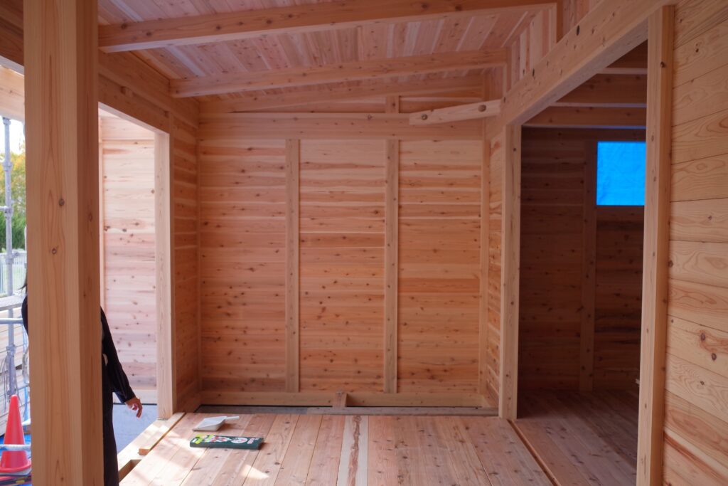 板倉造りの建築中の室内。明るい無垢材に柔らかい日差しが当たっている。