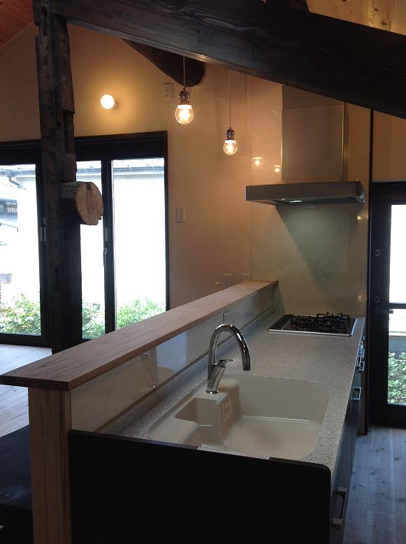 完成したキッチン、古材の梁が見える対面カウンター