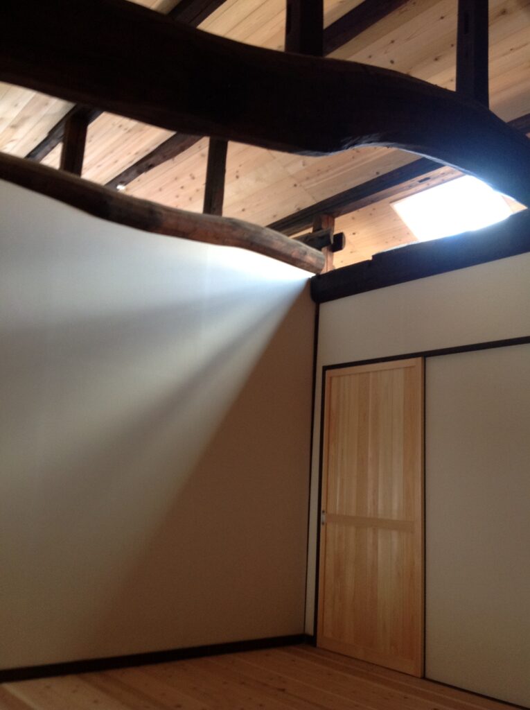 トップライトから光が射し込む2階の空間、古材の梁が美しい